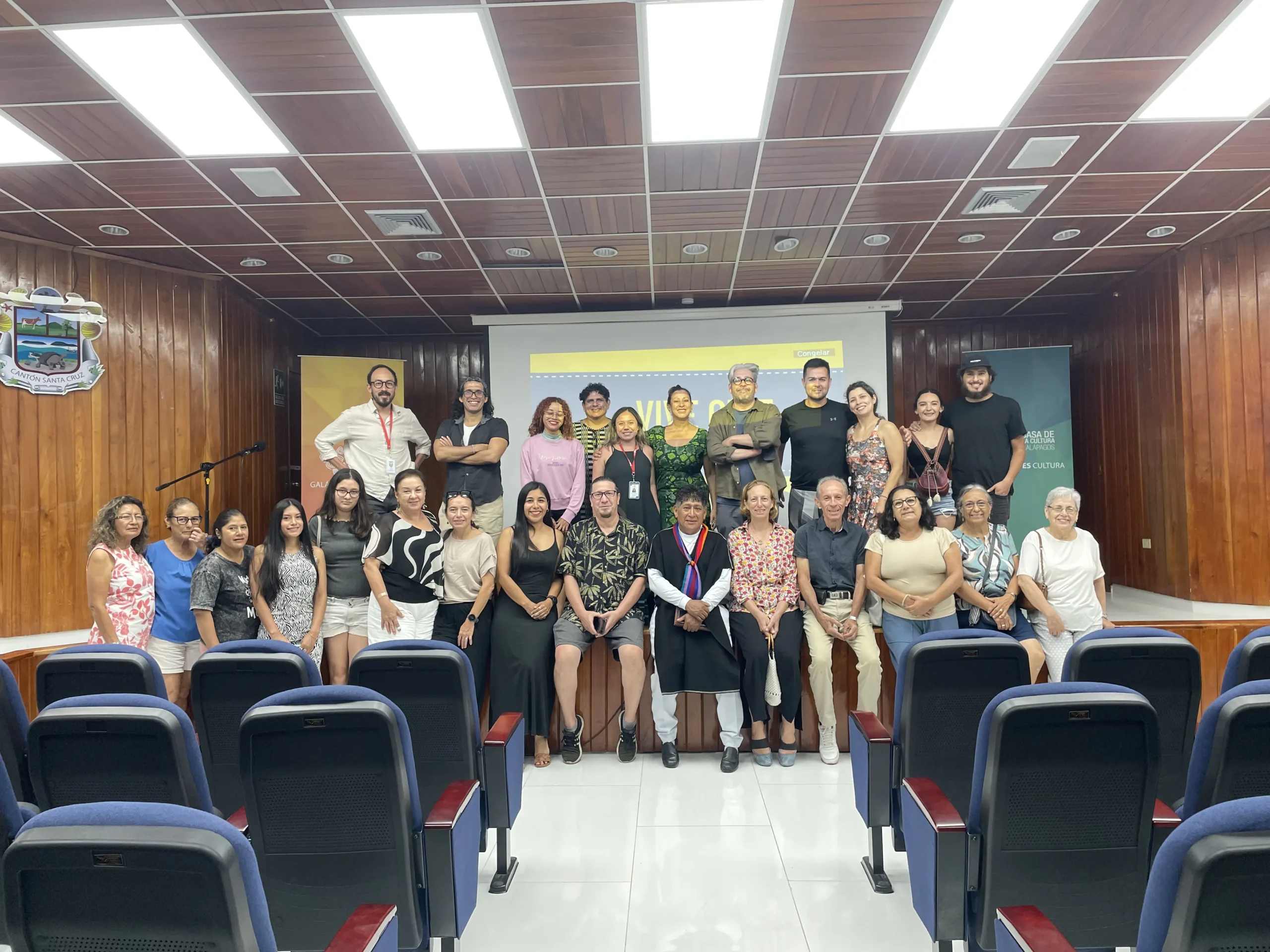 Familias y jóvenes de Isabela posan frente a la pantalla de Vive Cine después de la función