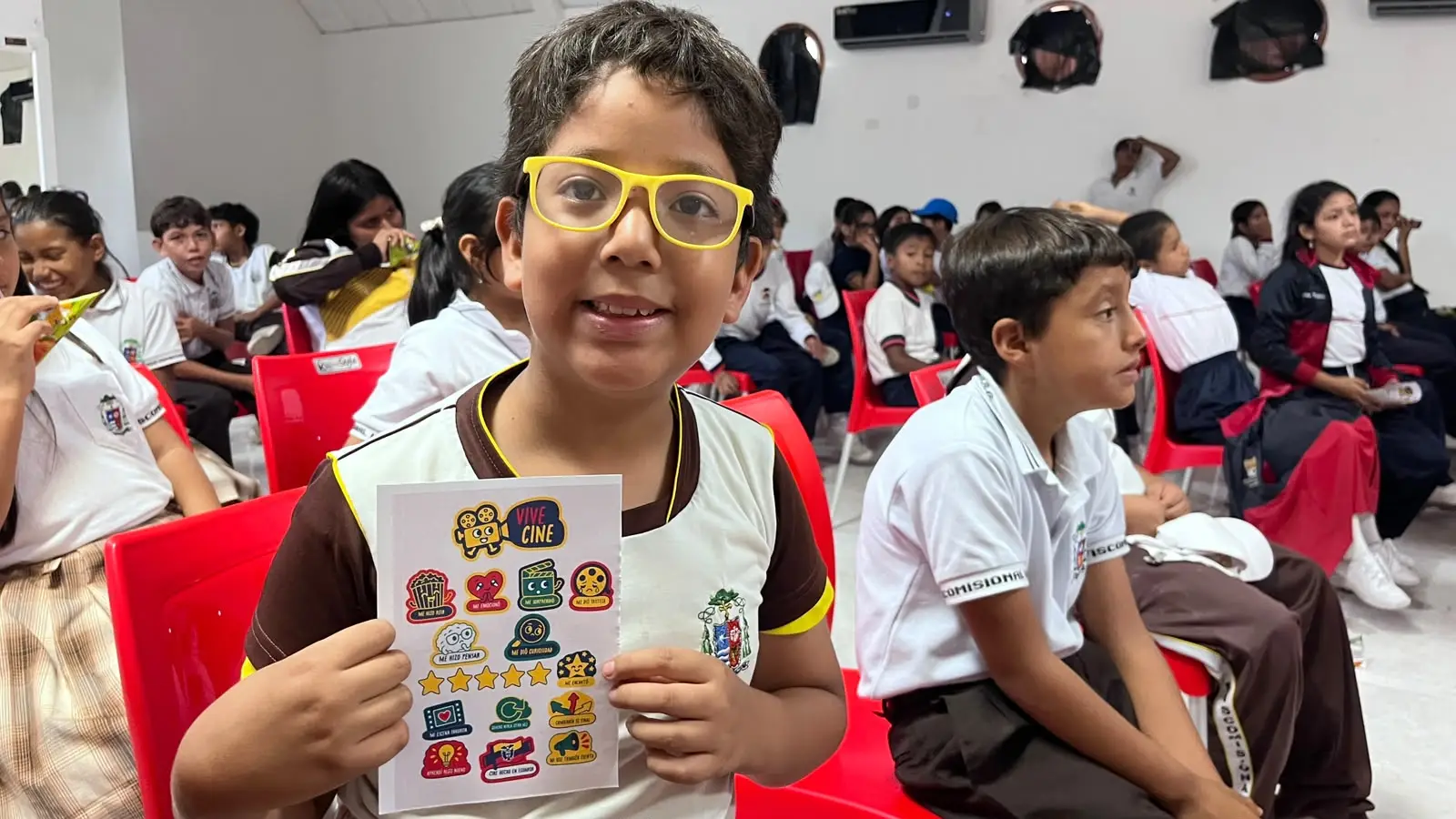 Un niño muestra su hoja de stickers de Vive Cine para marcar lo que sintió con la película